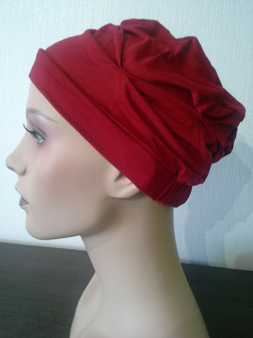 turban rouge uni posé sur une tête de mannequin