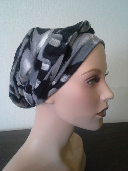 turban gris à motifs posé sur une tête de mannequin